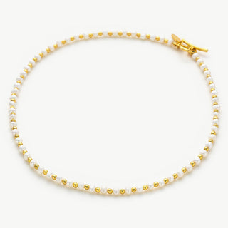 Gold Pearl Beaded Necklace, a radiant pearl charm accompanied by gleaming gold accents, capturing the essence of luxury and creating a stylish and timeless accessory.